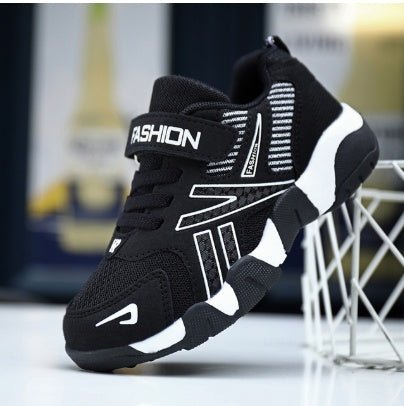 A pair of kids' sport sneakers with a black and white design, featuring a lace-up closure and the word 'FASHION' printed on the side.