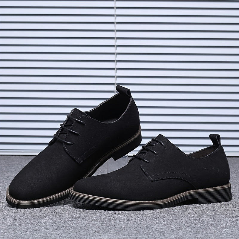 Pair of black leather shoes on a gray surface with a striped white and gray background