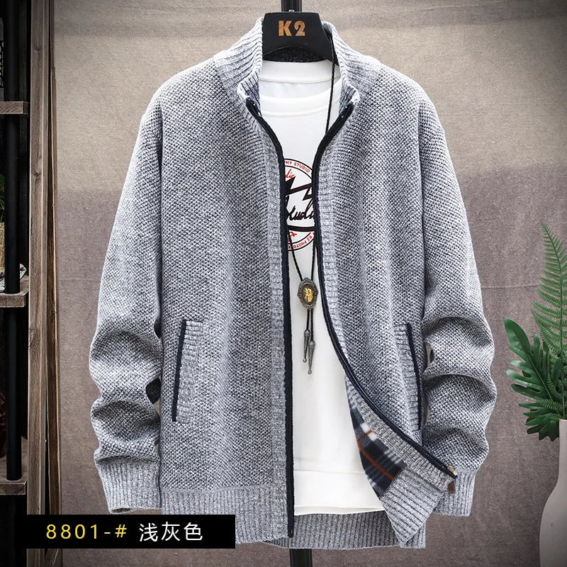 Gray zip-up sweater over a white shirt with a plant in the background