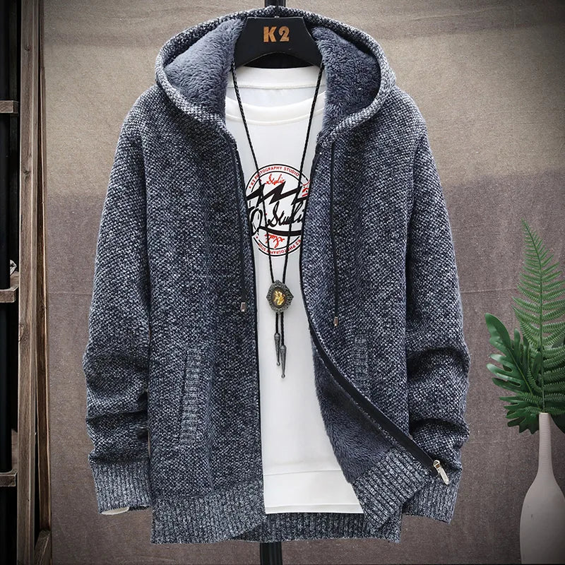 Blue knitted hoodie with a white shirt underneath on a gray background