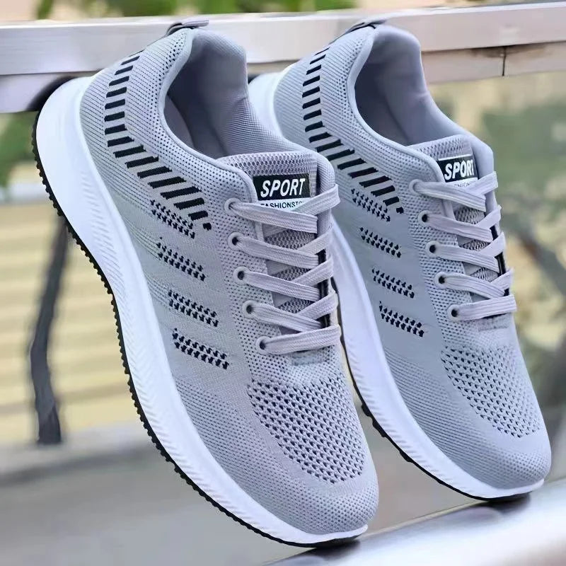 Pair of gray Men’s Casual Slip-On Sneakers with 'Sport' label on a blurred background