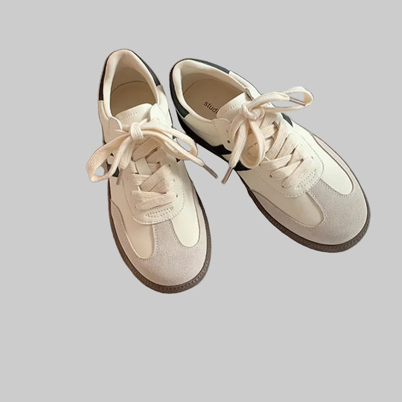 Pair of white sneakers on an open book with a white background