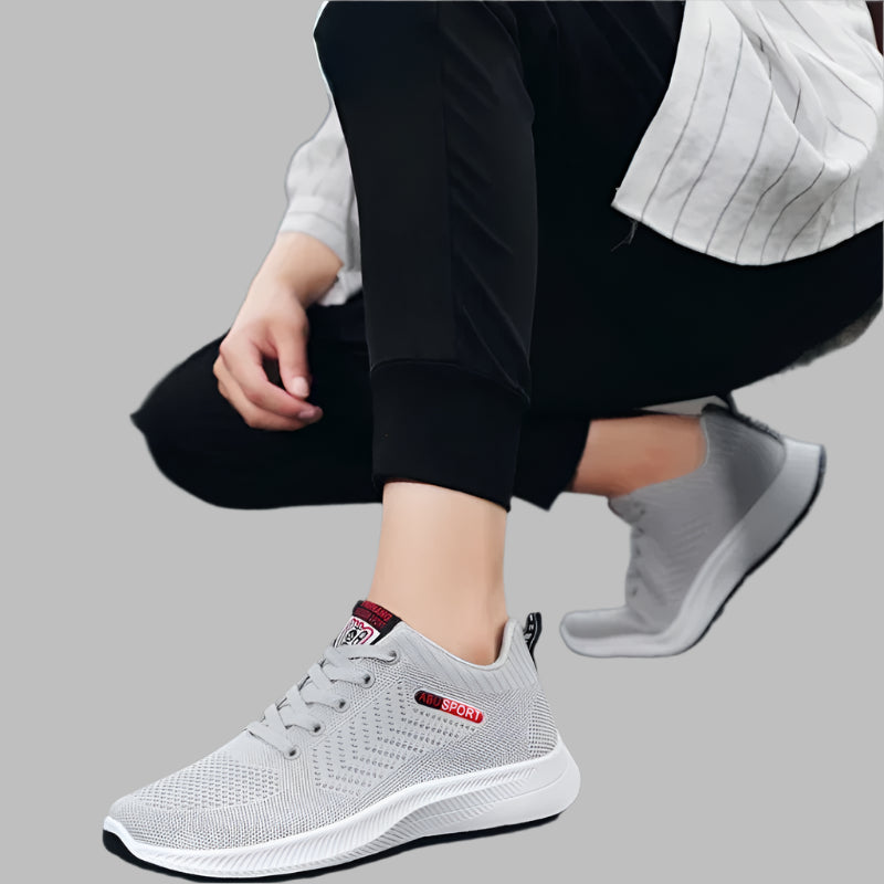 Person wearing gray athletic shoes on a dark surface with text overlay.