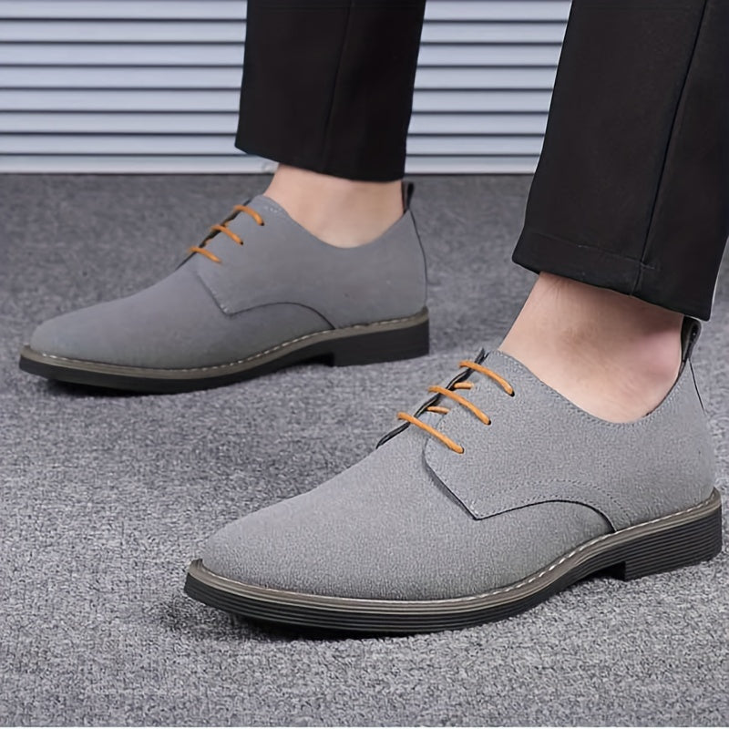 Gray dress shoes with brown laces worn by a person on a gray floor.
