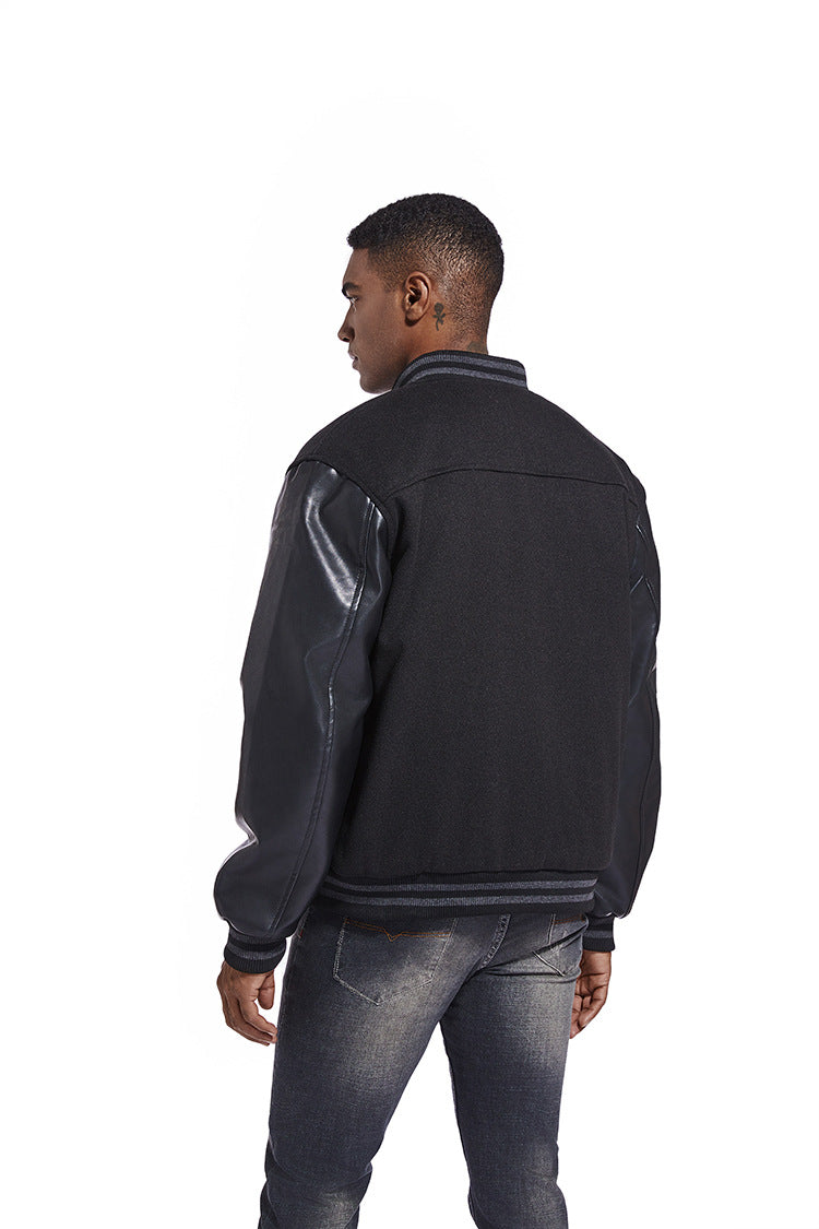 Man wearing a black American Baseball Jacket  with reflective accents on a white background